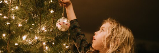 iStock Little Girl Decorating Christmas Tree with Ornaments