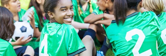 Beautiful African American girl smiling with her soccer team