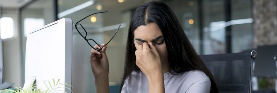 Depressed businesswoman rubbing eyes in office-121918