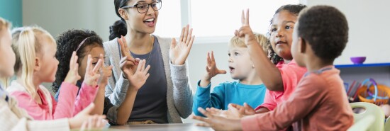 Multi-ethnic preschool teacher and students in classroom