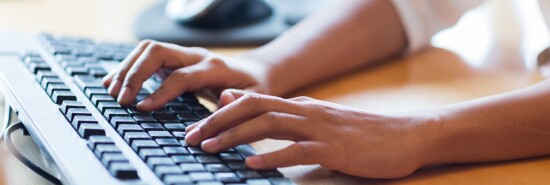 close up of female hands typing on keyboard