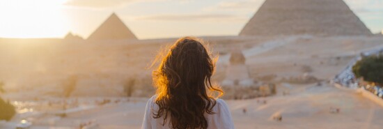 Woman standing on the  terrace on the  background of Giza pyramids