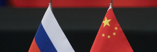 Russian and Chinese flags sit on a table.