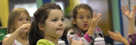 In this picture, several children are trying to learn sign language.