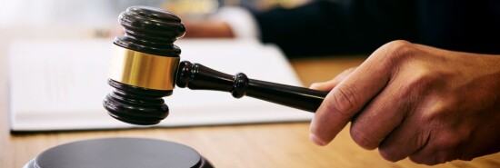 A person hits a flat surface with a gavel.