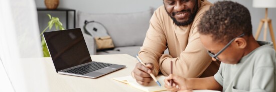 African American Boy Studying with Father at Home