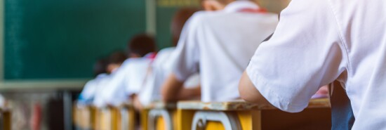 Rear view of middle school students studying in classroom