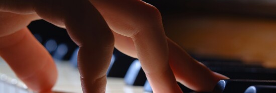 Hand of little girl playing the piano.